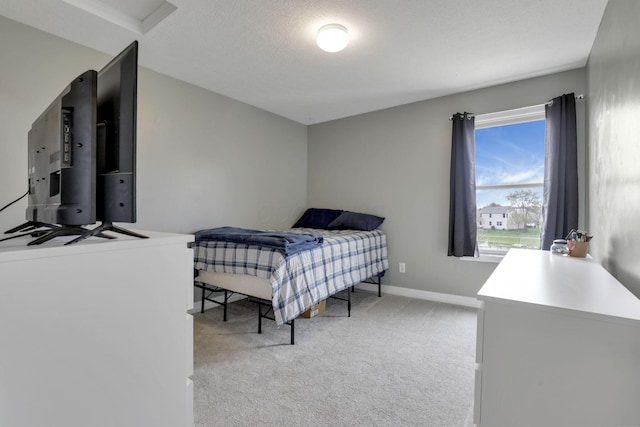 bedroom with baseboards and light carpet