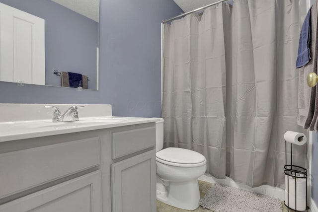 bathroom with a shower with curtain, vanity, a textured ceiling, and toilet