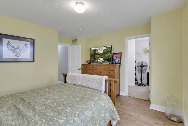 bedroom with baseboards, light wood-style flooring, and visible vents