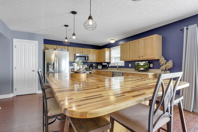 kitchen featuring dark wood finished floors, light brown cabinetry, stainless steel appliances, light countertops, and a textured ceiling