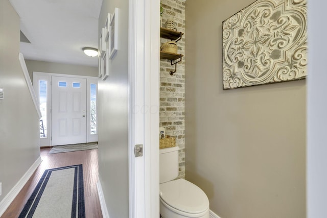 bathroom featuring toilet, wood finished floors, and baseboards