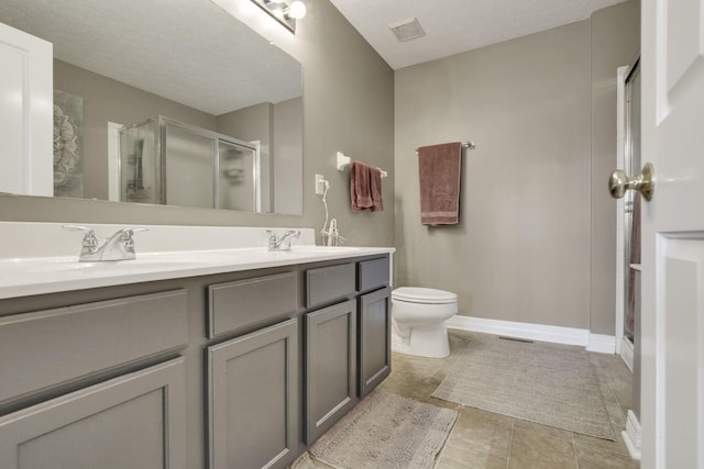 full bath with tile patterned floors, a sink, double vanity, toilet, and a stall shower