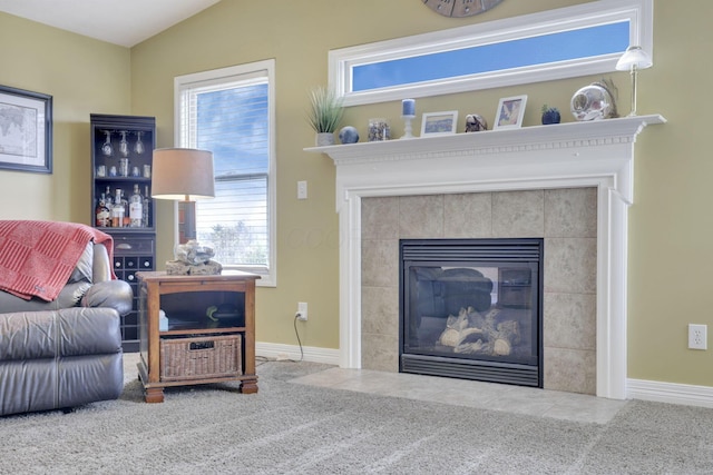 living area featuring baseboards and a tile fireplace