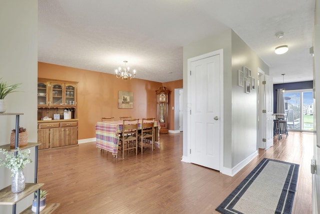 dining room featuring an inviting chandelier, wood finished floors, and baseboards