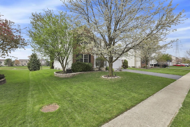 view of front of home featuring an attached garage, a front lawn, and aphalt driveway