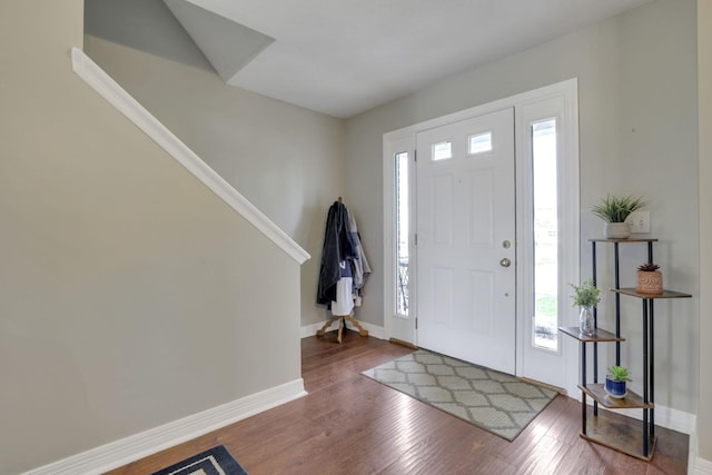 entryway featuring baseboards, a healthy amount of sunlight, and wood finished floors