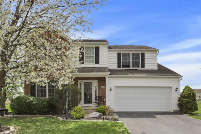 traditional home with brick siding, a front lawn, aphalt driveway, and a garage