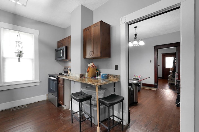 940 3rd St, Logan, OH 43138 - kitchen featuring stainless steel appliances, plenty of natural light, dark wood-style flooring, and a breakfast bar area