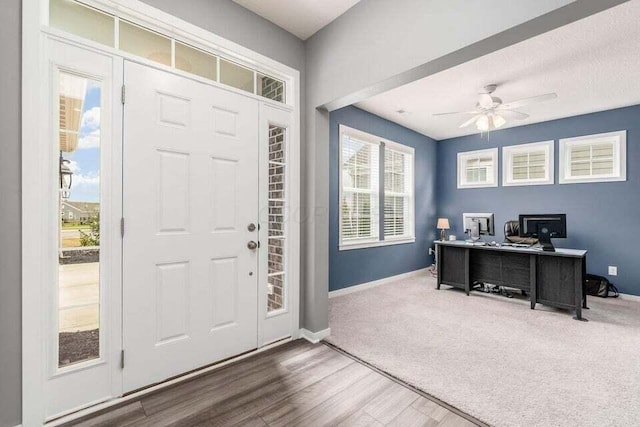 foyer featuring ceiling fan, baseboards, and wood finished floors