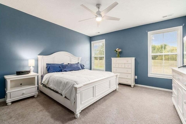 bedroom featuring light colored carpet, ceiling fan, baseboards, and visible vents