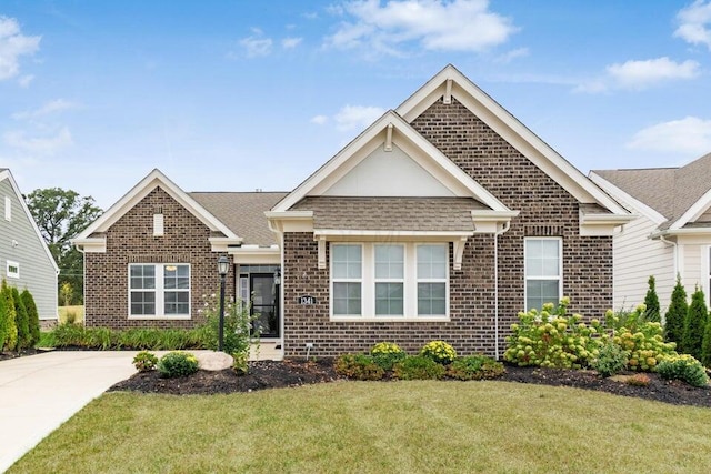 view of front facade featuring a front lawn, brick siding, and a shingled roof