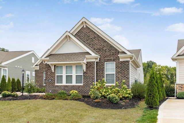 view of front of home featuring brick siding and a front yard