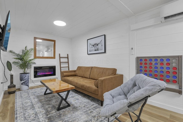 62579 Dunkle Creek Rd, Mcarthur, OH 45651 - living room featuring a glass covered fireplace, wood ceiling, a wall mounted AC, and wood finished floors