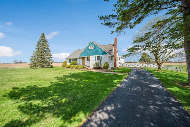 view of front of house with a chimney and a front yard