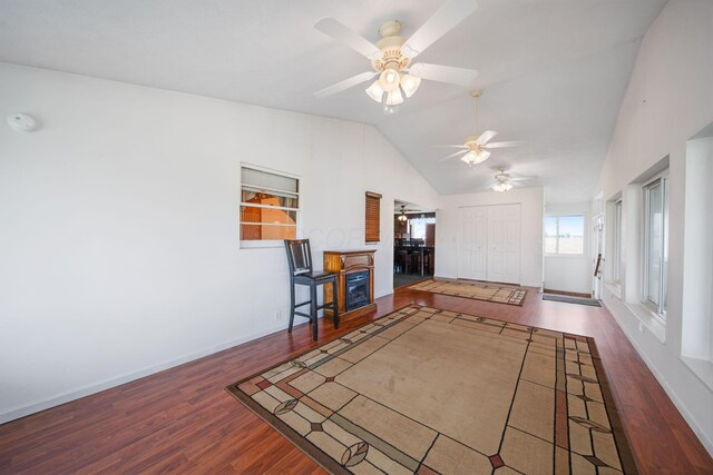 unfurnished living room with lofted ceiling, baseboards, wood finished floors, and ceiling fan