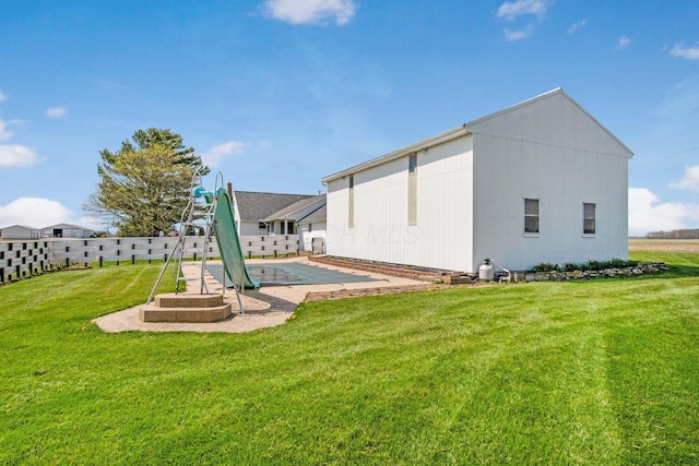 rear view of house featuring a yard and fence