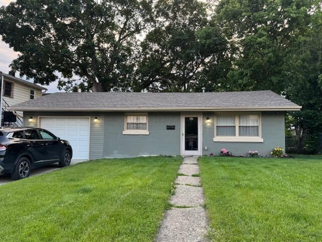 1031 S Washington St, Circleville, OH 43113 - view of front of house with a garage, a front lawn, and concrete block siding