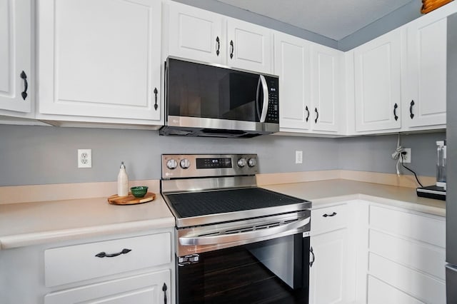 kitchen featuring light countertops, appliances with stainless steel finishes, and white cabinetry