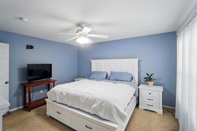 bedroom featuring baseboards, ceiling fan, and light carpet