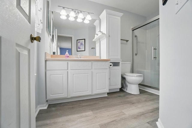 full bathroom with vanity, a stall shower, toilet, and wood finished floors