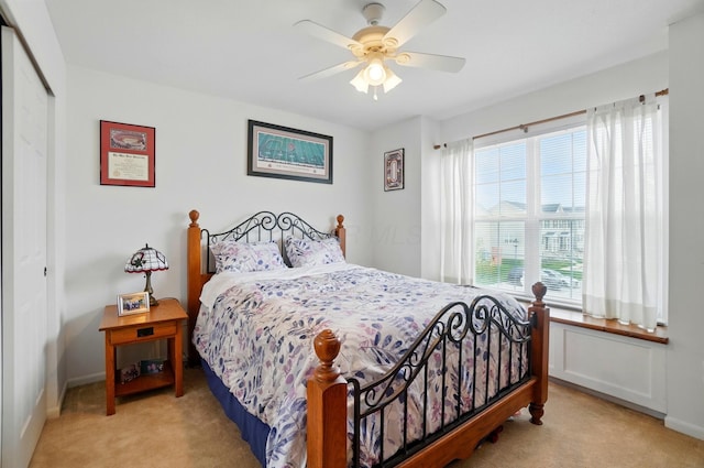 carpeted bedroom featuring a closet, baseboards, and ceiling fan