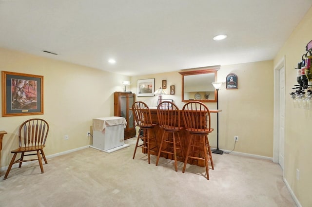 carpeted dining space featuring visible vents, a dry bar, baseboards, and recessed lighting