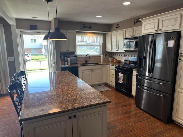 kitchen with a center island, a sink, recessed lighting, dark wood-type flooring, and black appliances