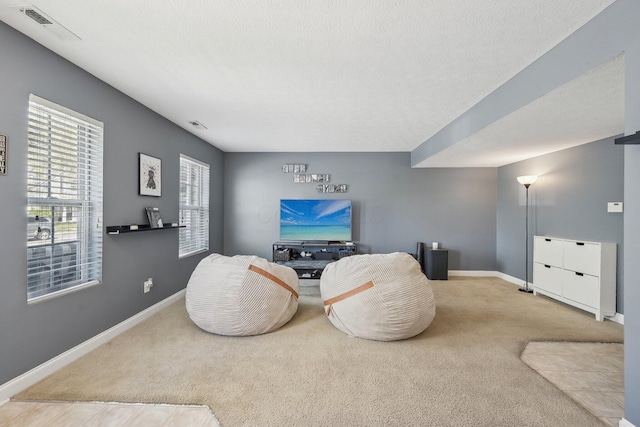 living area with carpet floors, baseboards, and visible vents