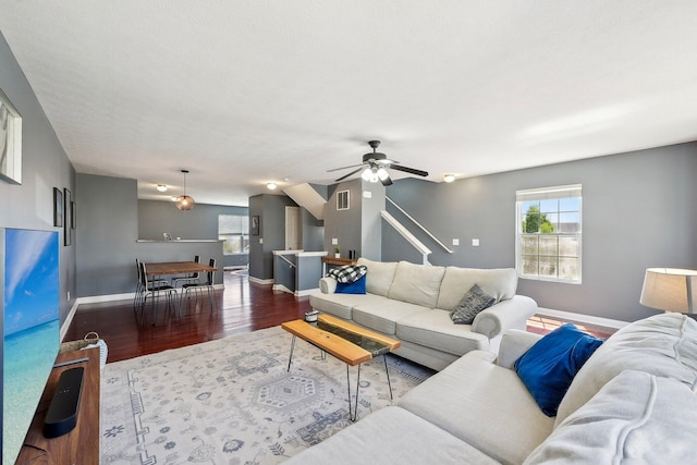living area with ceiling fan, baseboards, visible vents, and wood finished floors