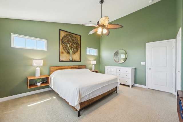 carpeted bedroom with a ceiling fan, baseboards, and multiple windows
