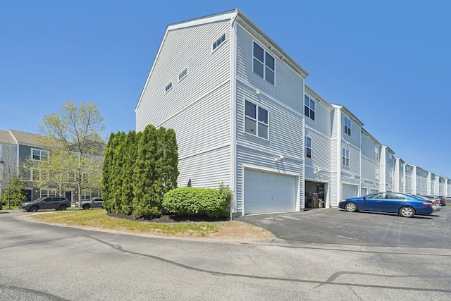 view of property exterior featuring a garage and aphalt driveway