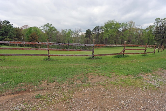 view of yard with fence and a rural view