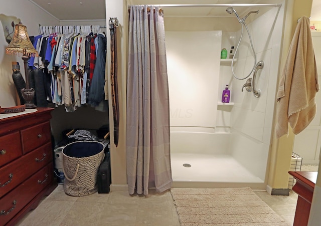bathroom featuring tile patterned floors, vanity, a shower stall, and a walk in closet