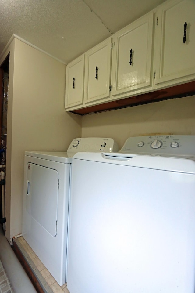 washroom featuring cabinet space and washer and clothes dryer