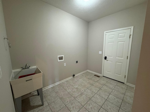 clothes washing area featuring laundry area, hookup for a washing machine, a textured ceiling, electric dryer hookup, and light tile patterned floors