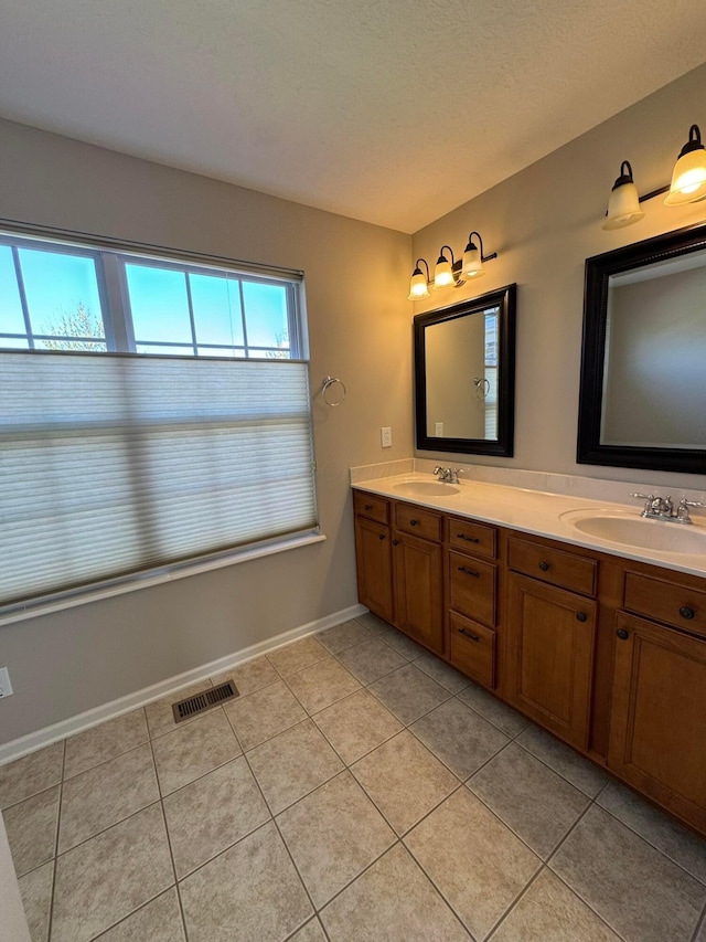 full bath with visible vents, a sink, and tile patterned floors