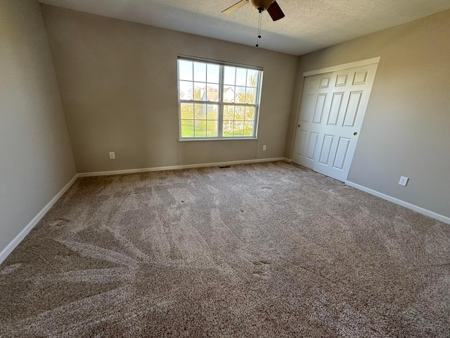 unfurnished bedroom featuring baseboards, carpet flooring, and a textured ceiling