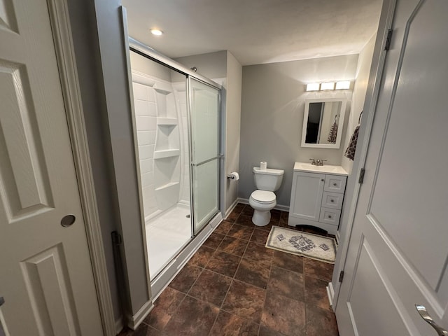 full bathroom with stone finish floor, a shower stall, vanity, baseboards, and toilet
