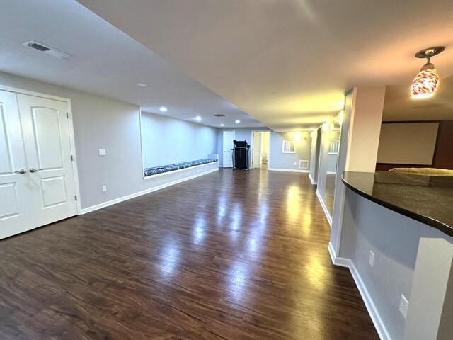 unfurnished living room featuring recessed lighting, baseboards, dark wood-style flooring, and visible vents