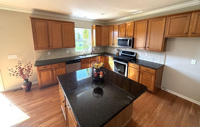 kitchen featuring a sink, appliances with stainless steel finishes, and brown cabinets