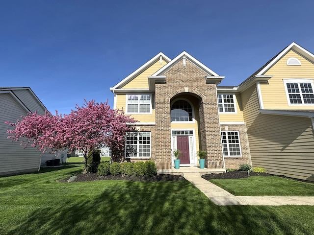 view of front of property featuring brick siding and a front yard