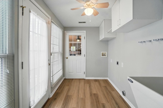 washroom with light wood finished floors, visible vents, hookup for an electric dryer, cabinet space, and washer hookup