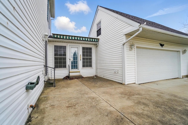view of side of property featuring concrete driveway and a garage