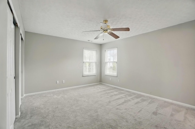 unfurnished bedroom featuring carpet, a textured ceiling, and baseboards