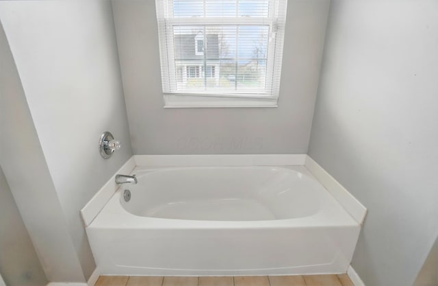 bathroom with a bath and tile patterned flooring