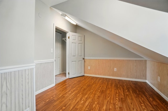 additional living space featuring lofted ceiling, baseboards, and wood finished floors