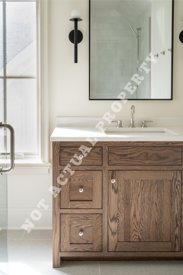 full bath featuring a shower with shower door and vanity