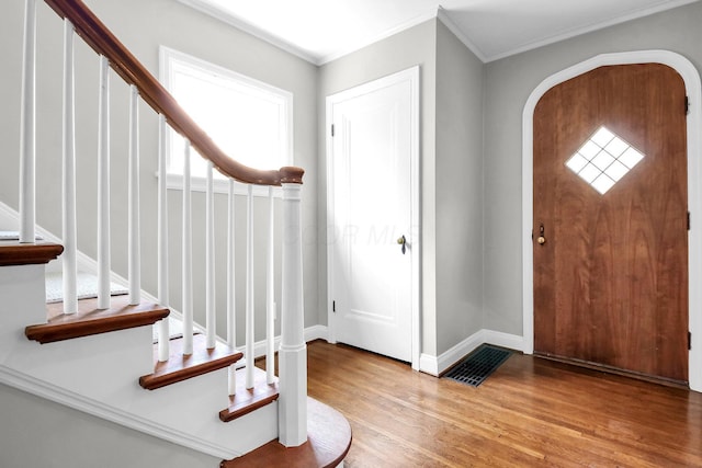 461 E N Broadway St, Columbus, OH 43214 - foyer entrance with stairs, wood finished floors, arched walkways, crown molding, and plenty of natural light