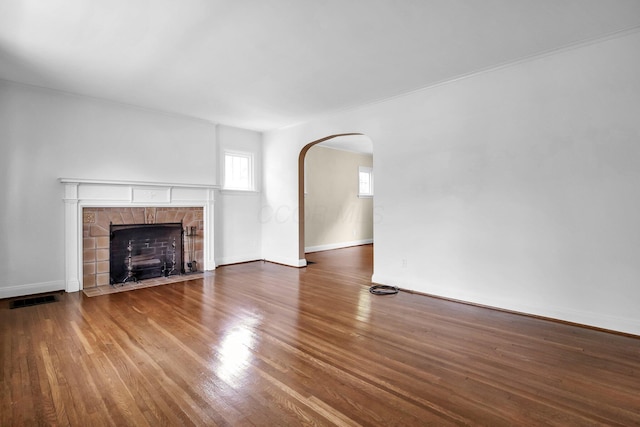 461 E N Broadway St, Columbus, OH 43214 - unfurnished living room featuring arched walkways, a fireplace, wood finished floors, and baseboards