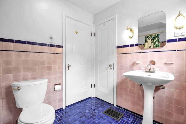 461 E N Broadway St, Columbus, OH 43214 - bathroom featuring tile walls, toilet, tile patterned flooring, wainscoting, and a shower with curtain
